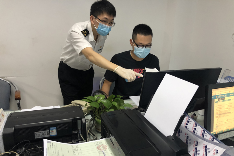 图为：关员指导企业自助打印原产地证书++开平海关摄
