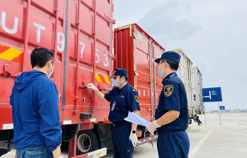 图为:海关关员为转关车辆拆封+侯俊摄 图为:海关关员为转关车辆拆封+侯俊摄