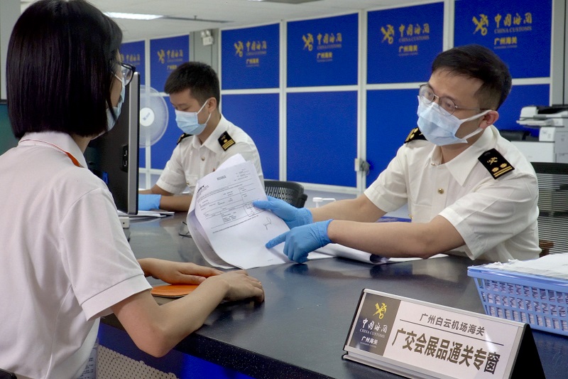 图为广州海关现场关员在广交会展品通关专窗指导企业办理展品入境手续。